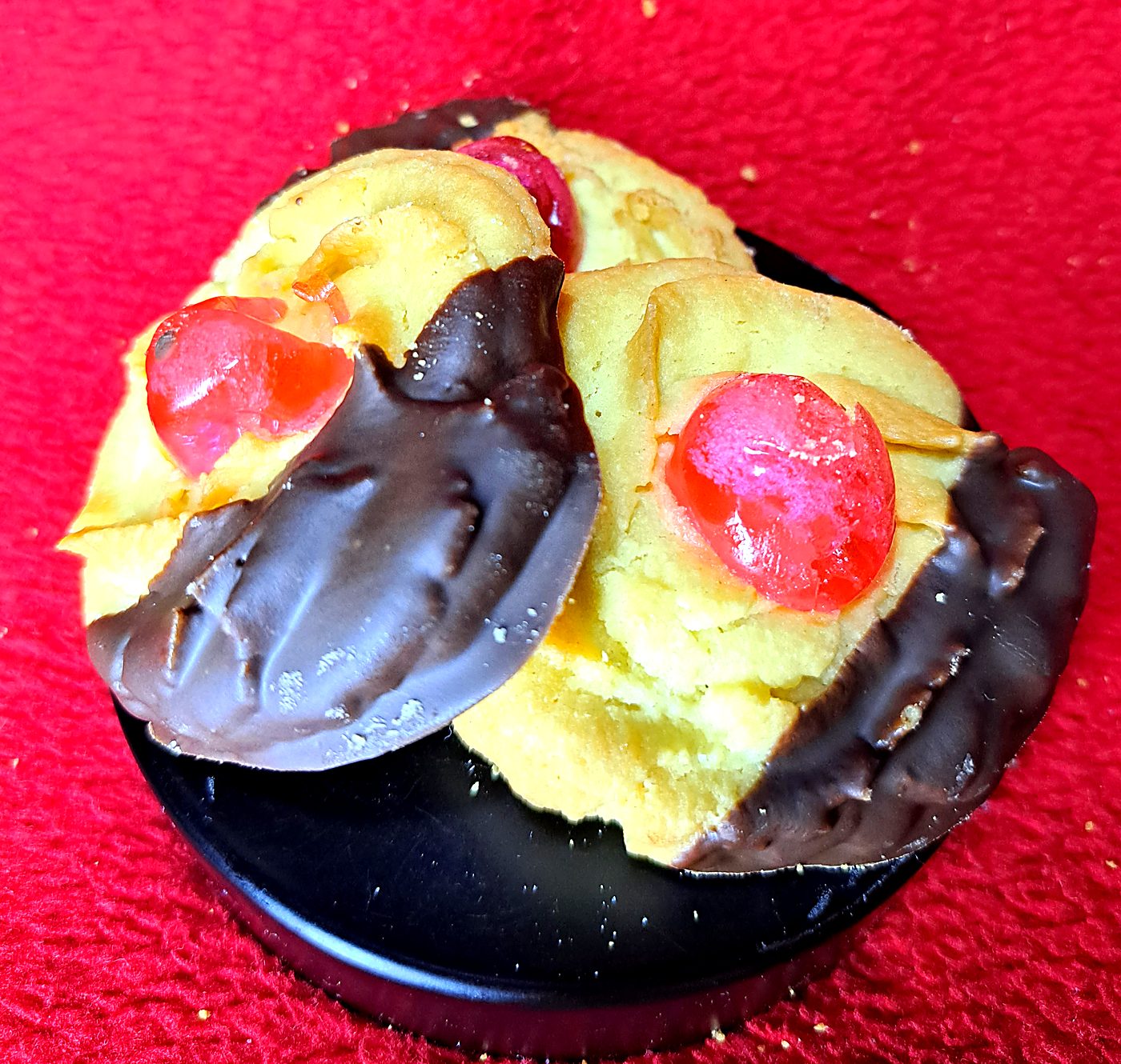Viennese cookies dipped in chocolate with glacé cherries