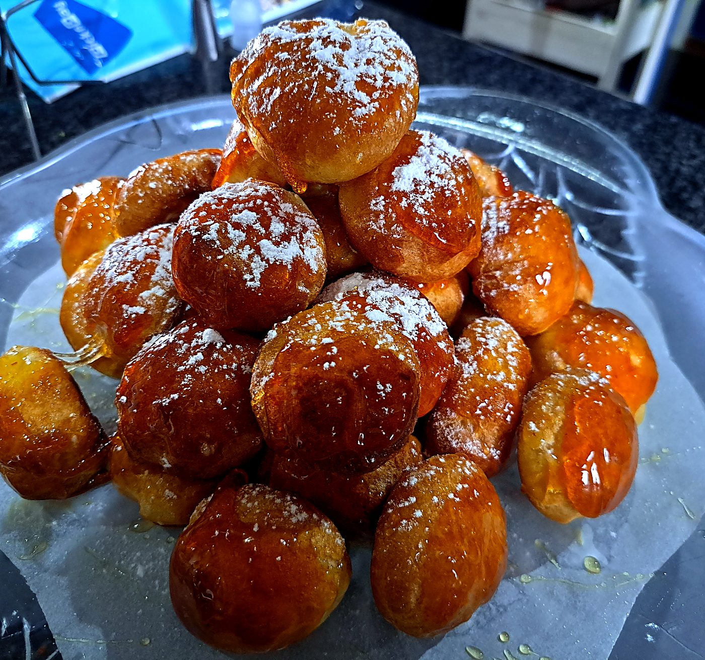 A pile of glazed, sugar-dusted profiteroles